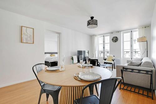 une salle à manger et un salon avec une table et des chaises dans l'établissement Elegant Apt - 1BDR 4P - Marais Place des Vosges, à Paris