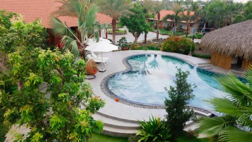 a swimming pool in a yard with trees and a building at Le Palmier Long An Boutique Resort - Free Outdoor Cinema in Ấp Kế Mỹ