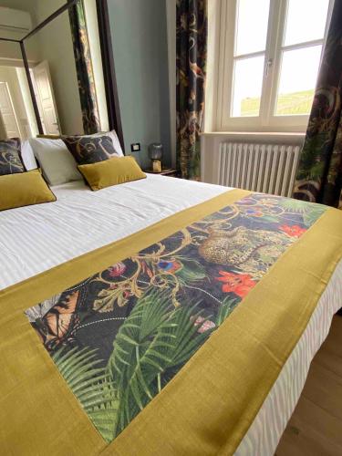 a bedroom with a large bed with a colorful blanket at Villa Chloé in Montecalvo Versiggia