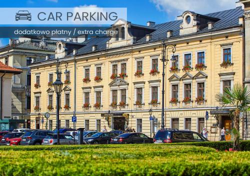 a large building with cars parked in front of it at Pollera in Kraków