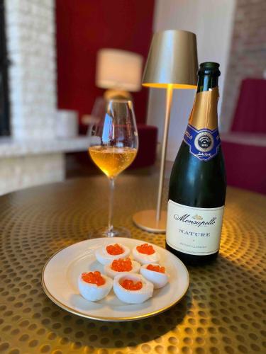 a bottle of wine and a plate of eggs and a glass at Villa Chloé in Montecalvo Versiggia
