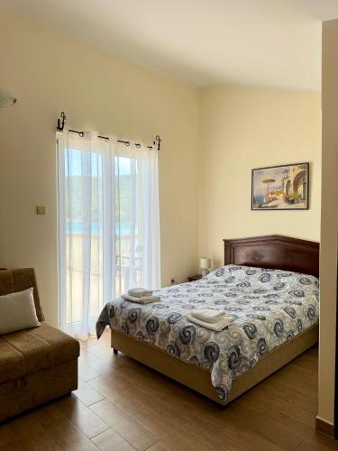 a bedroom with a bed and a chair and a window at Boka Bay Apartments in Herceg-Novi