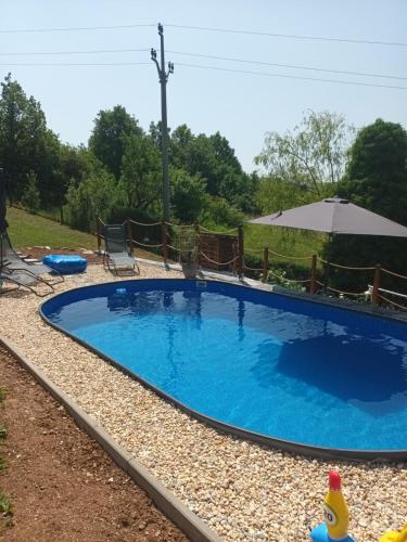 a large blue swimming pool in a yard at Villa Evetes in Jablonov nad Turnou