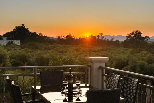 a table on a balcony with a sunset in the background at Solena in Tsikalariá