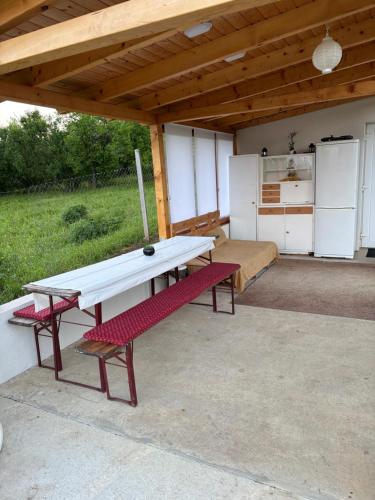 a picnic table and two benches under a pavilion at Nash-lak in Kaposvár