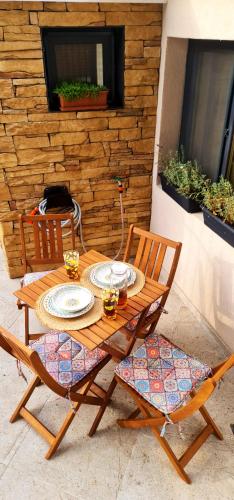 a wooden table and chairs with plates and glasses on it at Morava 1 Asparuhovo Beach Holiday House in Varna City