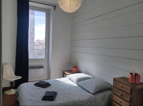 une chambre avec un lit et une fenêtre dans l'établissement Charmant T3 - métro Chartreux 10ALT, à Marseille