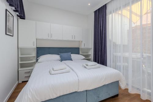 a bedroom with a large bed with two towels on it at Fülöp Panzió Apartments near Lake Balaton in Révfülöp