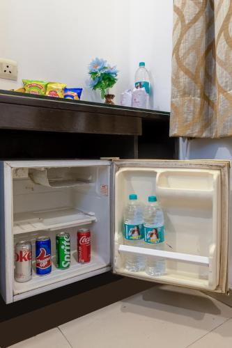 an open refrigerator with soda and water in it at Hotel Chanchal Continental - New Delhi City Centre in New Delhi