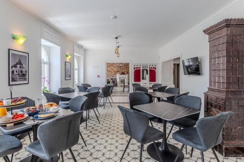 a restaurant with tables and chairs and a fireplace at Fülöp Panzió Apartments near Lake Balaton in Révfülöp