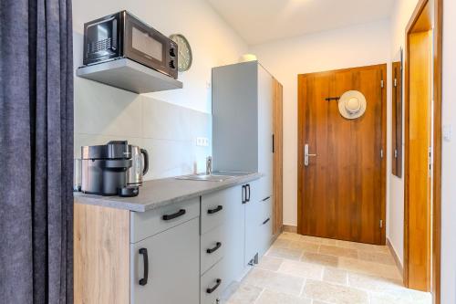 a small kitchen with a sink and a microwave at Fülöp Panzió Apartments near Lake Balaton in Révfülöp