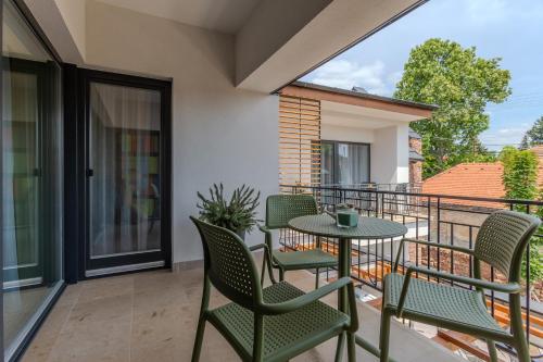 a patio with chairs and a table on a balcony at Fülöp Panzió Apartments near Lake Balaton in Révfülöp