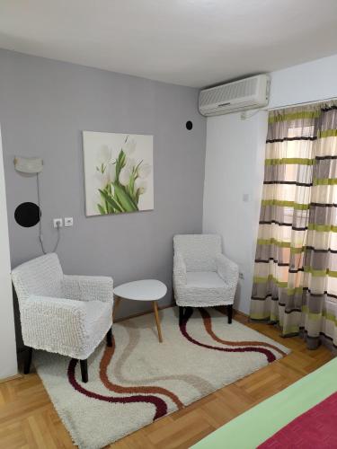 a living room with two chairs and a table at Apartmani Abeona in Budva