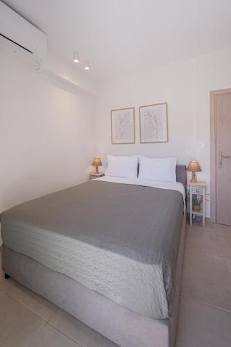 a bedroom with a large bed with two pictures on the wall at Anemos Luxury Home in Pogoniá