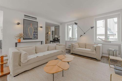 un salon avec deux canapés blancs et deux tables dans l'établissement 502254 - Spacious duplex apartment for 12 people near Les Halles, à Paris