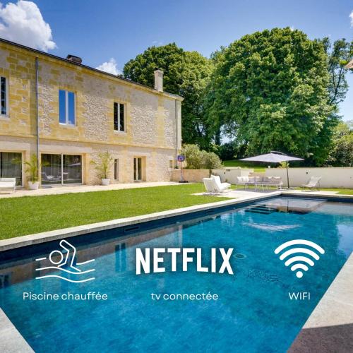 une grande piscine devant un immeuble dans l'établissement Le Clos Saint Jean, à Tizac-de-Curton