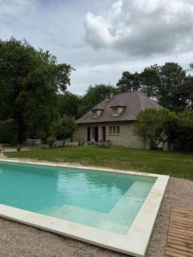 une maison avec une piscine devant une maison dans l'établissement Le Peruguet - maison avec piscine et bois privé, à Margueron