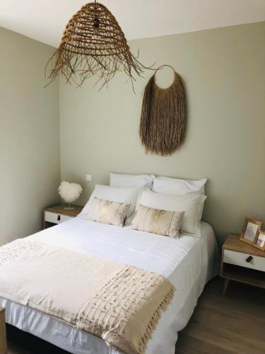 une chambre avec un grand lit avec des draps blancs dans l'établissement LE COCOONING 50 m de la plage en baie de somme, à Cayeux-sur-Mer
