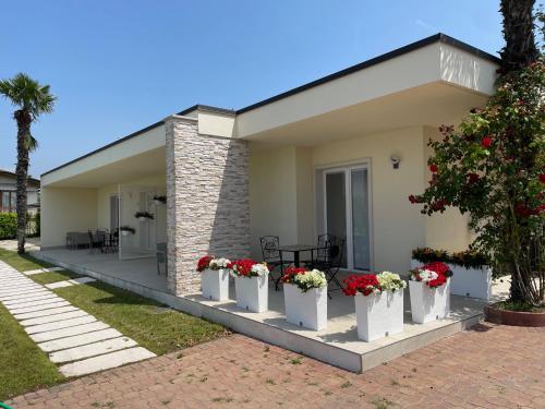 a house with flowers in white containers on the porch at Hotel Panoramica in Bardolino