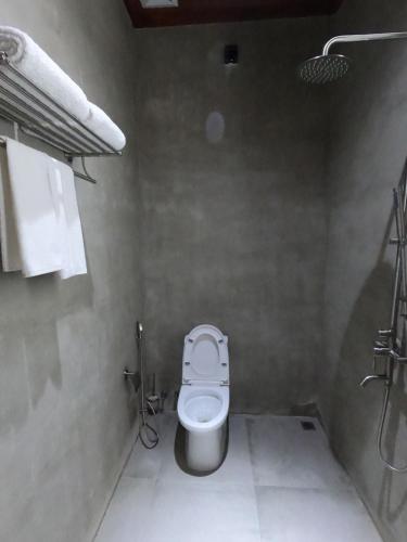 a small bathroom with a toilet and a shower at Blue Coral Vashafaru Maldives in Vashafaru