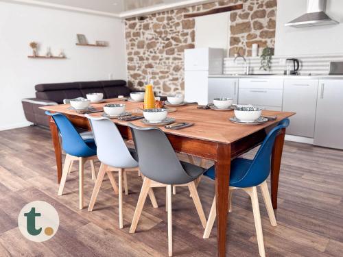 Il dispose d'une cuisine et d'une table à manger avec des chaises bleues. dans l'établissement Tranquiloue - Maison 8 pers - Puy du Fou 15min, aux Herbiers