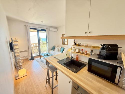 une cuisine avec un comptoir avec un micro-ondes dans l'établissement Coudou YourHostHelper, à Six-Fours-les-Plages