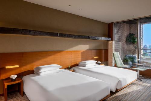 two beds in a hotel room with a window at Hyatt Regency Tokyo in Tokyo