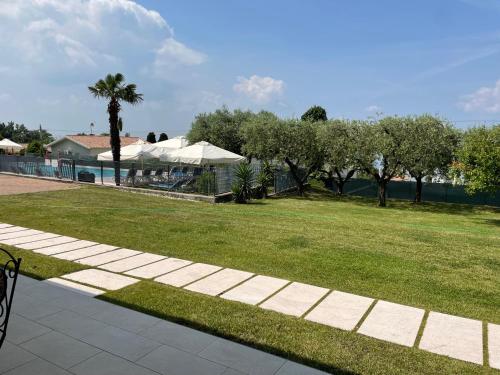 a walkway in a park with a lawn and trees at Hotel Panoramica in Bardolino
