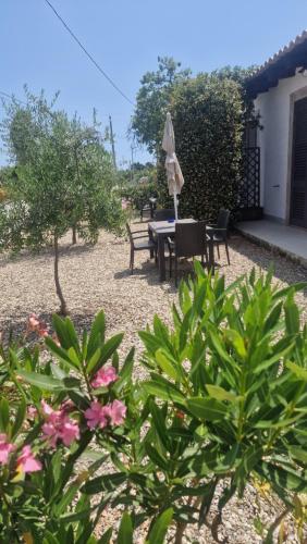 a patio with a table and chairs and flowers at Le Case Al Quadrato Residence in Siracusa