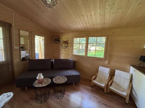 a living room with a couch and a table at Familijny domek nad jeziorem in Górzno