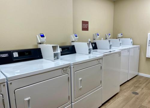 a row of white washing machines in a room at TownePlace Suites by Marriott Portland Beaverton in Beaverton