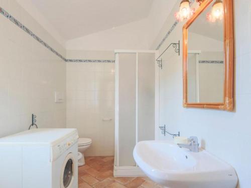 une salle de bain blanche avec un lavabo et un miroir dans l'établissement Casa Novella - Argonauti Vacanze, à Procchio