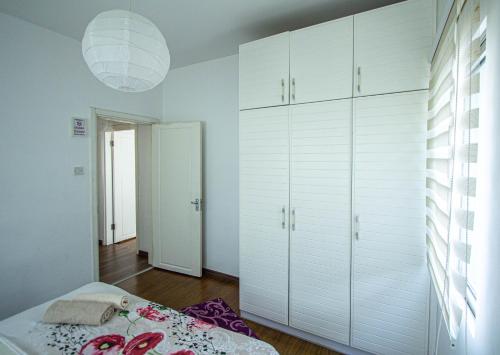 a bedroom with white cabinets and a bed at RIX Apartments in Kérynia