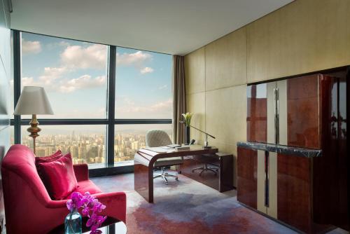 a living room with a desk and a large window at Sofitel Kunming in Kunming
