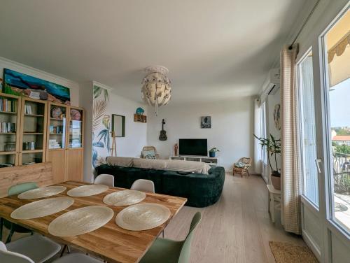 una sala de estar con una mesa y un sofá en Appartement familial - Vue mer, en Bastia