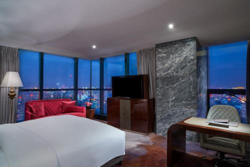 a hotel room with a bed and a large window at Sofitel Kunming in Kunming