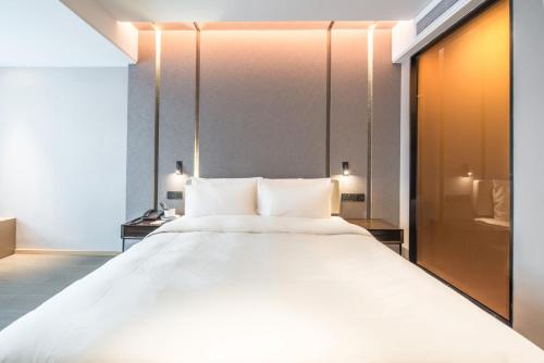 a large white bed in a hotel room at Atour Hotel Shenzhen Baoan International Airport in Bao'an