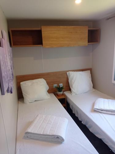 deux lits dans une petite pièce avec des draps blancs dans l'établissement Douce Provence - Provence Cote d'Azur, à Vidauban