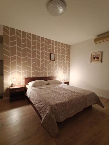 a bedroom with a bed and a wall with a pattern at Apartments Miljas in Cavtat