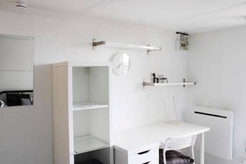 une pièce blanche avec un bureau blanc et des étagères dans l'établissement Beautiful studio for 2 in Versailles, à Versailles