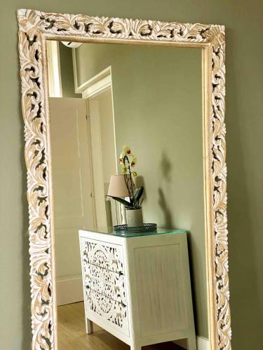 a mirror with a white frame on a wall at Villa Chloé in Montecalvo Versiggia