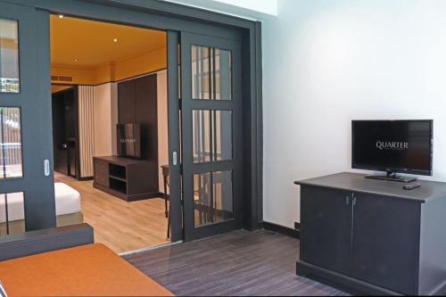 a room with a room with a television and a bedroom at The Quarter Saphankhwai by UHG in Bangkok