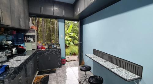 a kitchen with black cabinets and a counter top at Sarah's Garden BnB & Spa in Tontunan