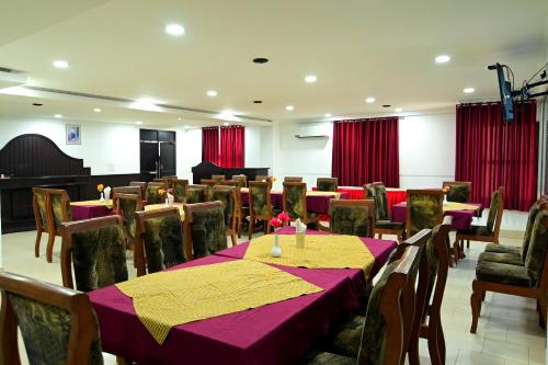 a conference room with tables and chairs and a piano at Hotel Misty Grand Kodenchery in Kodenchery
