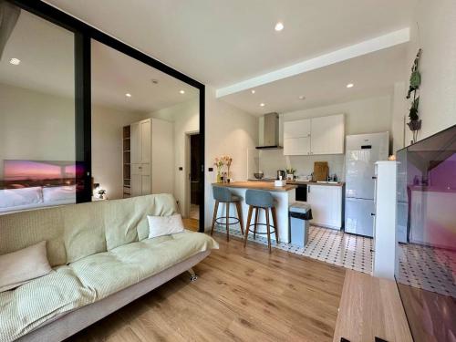 Una sala de estar con un sofá y una cocina. en JU3 Halo NEW ВатСaп66935B2I976, en Nai Yang Beach