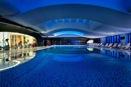 a swimming pool in a building with a blue ceiling at Sofitel Kunming in Kunming