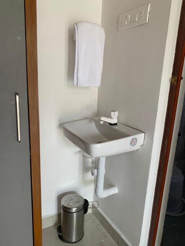 a sink in a bathroom with a towel on the wall at Love Green Resorts in Palladam