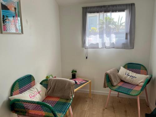 a living room with two chairs and a table at Cocon cosy entre terre & mer in Le Fenouiller