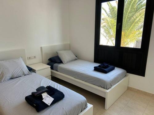 a room with two beds and a window at B16 caleton blanco in Puerto del Carmen