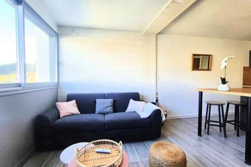 un salon avec un canapé bleu et une table dans l'établissement Charming 30 m apt marina view refurbished 2025, à Saint-Cyprien